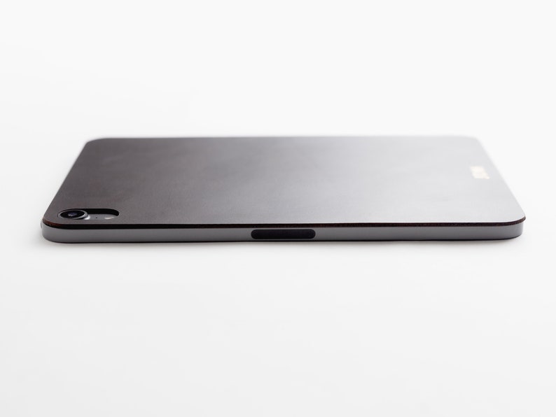 May include: A sleek, silver-coloured tablet computer with a black camera lens and a black power button on the side.