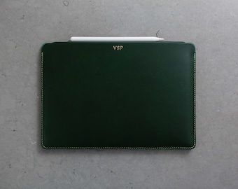 May include: A dark green leather iPad case with a gold stitched border and the initials "VSP" embossed in gold on the front.