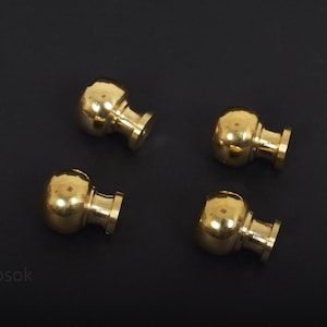 Op de afbeelding: Vier ronde gouden kastknoppen met een gladde, glanzende afwerking. De knoppen hebben een eenvoudig, klassiek ontwerp.