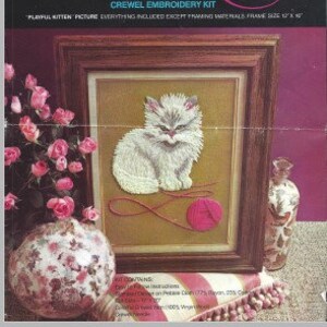 Op de afbeelding: Een crewel borduurset met een speels kittenbeeld. De set bevat alles behalve de materialen voor het inlijsten. De framemaat is 25,4 cm x 30,5 cm.