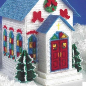 May include: White plastic canvas tissue box cover shaped like a church with a blue roof, red door, and green wreath. The cover is 15.3 inches by 7 inches.