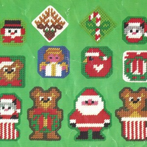 May include: A set of 12 Christmas-themed plastic canvas patterns featuring a variety of designs, including a snowman, reindeer, candy cane, angel, bird, gift box, and Santa Claus.