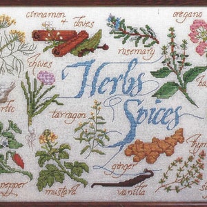 Può includere: Un ricamo a punto croce che presenta una varietà di erbe e spezie, tra cui aneto, aglio, erba cipollina, dragoncello, senape, peperoncino rosso, rosmarino, origano, basilico, timo, zafferano, zenzero, cannella, chiodi di garofano e vaniglia. Il disegno è circondato da una cornice in legno e include il testo "Erbe & Spezie".