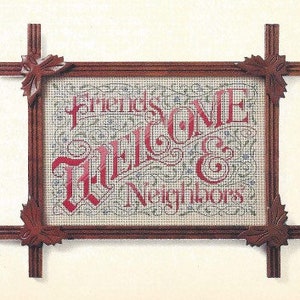 May include: A framed cross-stitch with a red and white welcome sign that reads "Friends & Neighbors Welcome". The frame is made of dark wood with decorative corners.