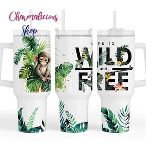 May include: White travel mug with a handle and straw. The mug features a watercolour design of a monkey surrounded by tropical leaves and the words "LIFE IS WILD and FREE". The design includes green foliage and gold accents.
