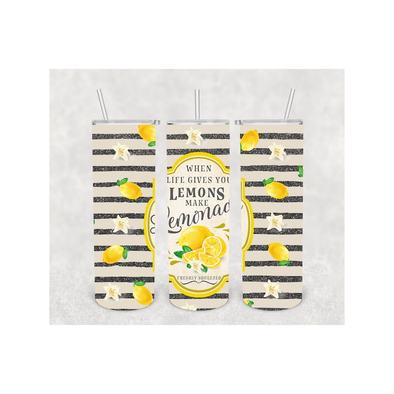 Pu&ograve; includere: Tre bicchieri in acciaio inossidabile con cannucce. I bicchieri presentano un design di limoni gialli, fiori bianchi e strisce nere su sfondo beige. Il bicchiere centrale ha il testo "When life gives you lemons make lemonade, freshly squeezed."