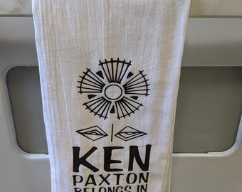 Flour sack towel that says what you are thinking, even Ken Paxton knows he belongs in prison.