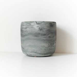 May include: A gray marbled ceramic planter with a rounded bottom.