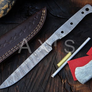 Peut inclure: Un couteau en acier de Damas avec une lame à motifs et un étui en cuir marron. Le couteau a une construction à soie pleine et est accompagné de goupilles métalliques et de papier abrasif rouge. Le couteau est présenté sur une surface en bois sombre.