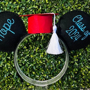 May include: Black felt Mickey Mouse ears with a red graduation cap and white tassel. The left ear has the word "Hope" embroidered in blue thread. The right ear has the text "Class of 2024" embroidered in blue thread.