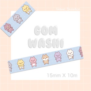 May include: A blue and white washi tape with a repeating pattern of cute cartoon bears wearing diapers. The tape is 15mm wide and 10m long. The text "COM WASHI" is written in white on a white background. The text "Velvet Skeleton" is written in black on a white background.
