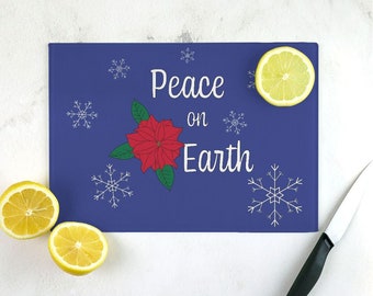 Christmas poinsettia and snowflake design "Peace on Earth" tempered glass cutting board