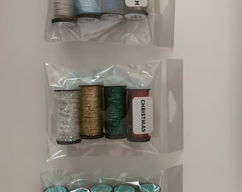 May include: Three bags of colorful, glittery craft wire. The bags are labeled "Hanukkah", "Christmas", and "Halloween".