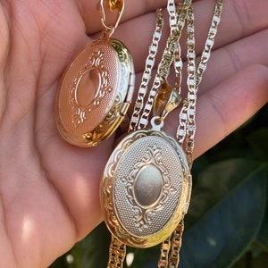 Puede incluir: Dos collares con medallones ovalados de oro con dise&ntilde;os intrincados. Los medallones est&aacute;n en una cadena de oro.