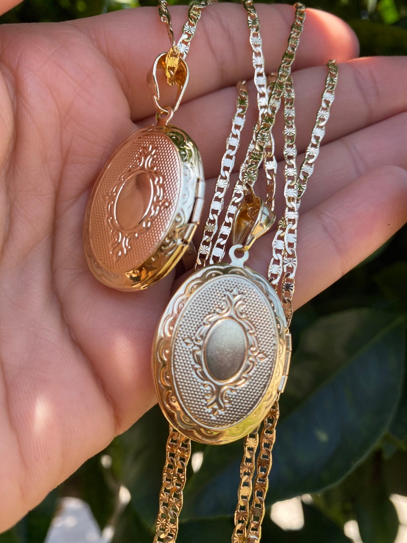 Puede incluir: Dos collares con medallones ovalados de oro con dise&ntilde;os intrincados. Los medallones est&aacute;n en una cadena de oro.