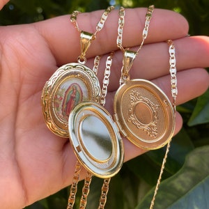 Puede incluir: Dos collares con medallones ovalados de oro y cadenas. Un medall&oacute;n presenta una imagen religiosa de la Virgen Mar&iacute;a. El otro medall&oacute;n tiene un dise&ntilde;o decorativo.
