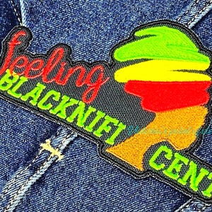 May include: Black and green embroidered patch with the text "Feeling Blacknift Cent" in a red and green font. The patch features a stylized image of a person's head with a green, yellow, and red hat.
