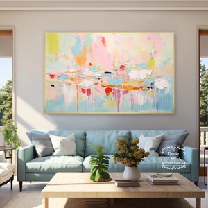 May include: Abstract painting with a colorful palette of pink, blue, yellow, and orange. The painting has a textured, layered look and is framed in a gold frame.