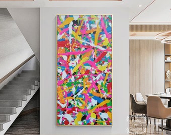 May include: Abstract painting with a colorful, splatter-style design. The painting features a variety of colors, including pink, yellow, blue, green, and white. The painting is framed in a gold frame.