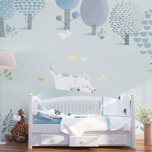 May include: A light blue nursery wall mural with a white dog sleeping in a field of green grass. The mural features blue and white trees with yellow butterflies flying around them.