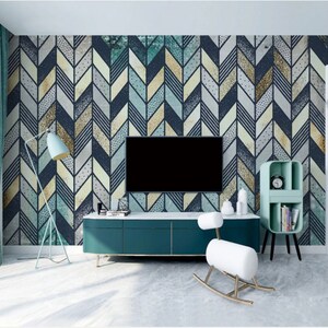May include: A living room interior design with a teal blue entertainment center, a white rocking horse, and a teal blue bookshelf. The wall is covered with a geometric wallpaper with a chevron pattern in shades of blue, yellow, and gray.