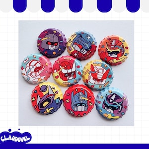 May include: A collection of nine circular bottle caps featuring colourful, stylised cartoon illustrations of robot character heads. Each cap displays a unique character design in vibrant shades of red, blue, purple, and yellow, accented with small decorative symbols like hearts, stars, and planets.