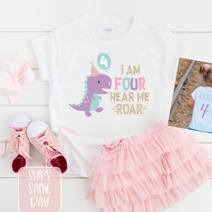 May include: White t-shirt with a purple dinosaur holding a balloon that says "4". The text on the shirt says "I am Four Hear Me Roar". The back of the shirt has a white "4" on it.