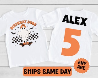 May include: Two white t-shirts, one with a ghost wearing a hat and skateboarding with the text "Birthday Dude" and the other with the name "Alex" and the number "5" in orange.