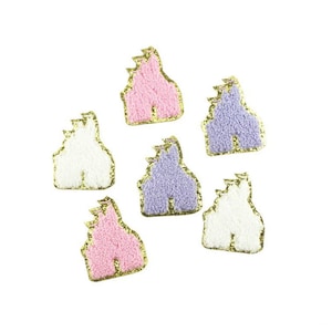 May include: Six felt castle patches in pink, white, and purple with gold glitter trim.