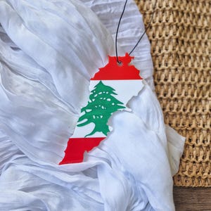 Peut inclure: Un tissu blanc avec une silhouette rouge, blanche et verte du Liban avec le cèdre au centre.