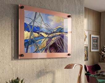 May include: A rectangular wall art piece featuring an abstract landscape painting with blue, gold, and purple tones, encased in a rose gold frame with four black corner mounting bolts, displayed on a textured gray wall above a wooden console table.