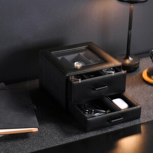 a table with a lamp and a black box on it
