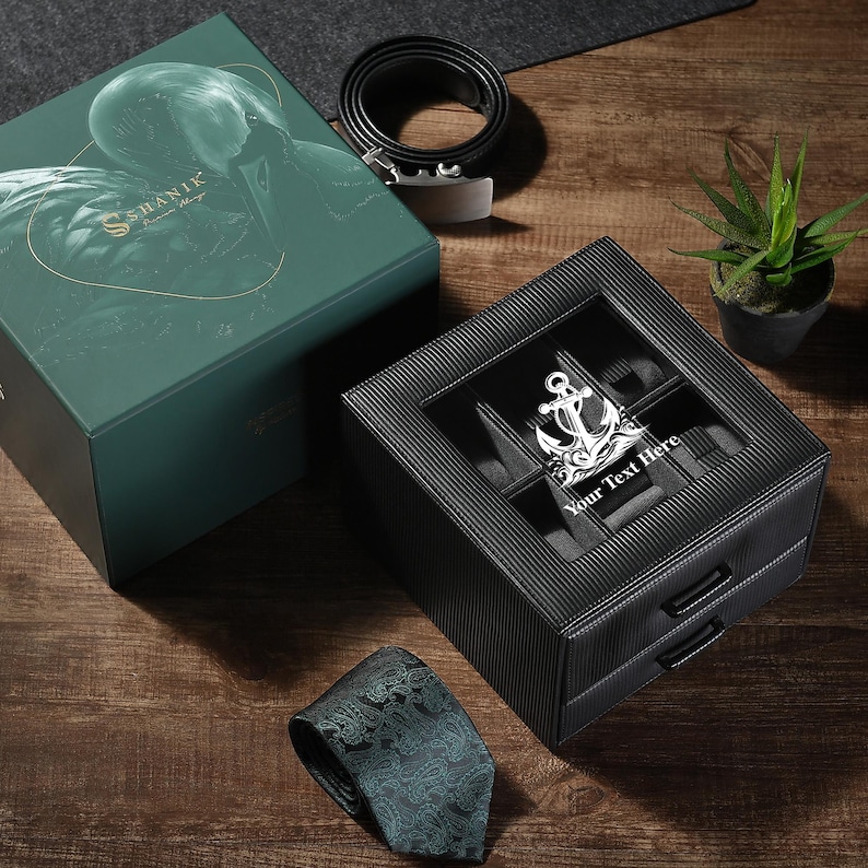 a watch sitting in a box next to a plant