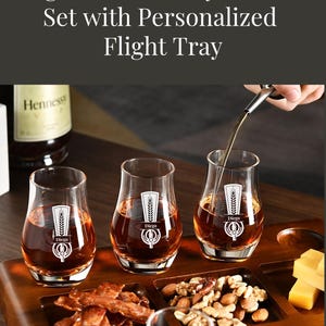 a set of engraved whiskey glasses set with personalized flight trays, accompanied by a bottle of Hennessy whiskey.