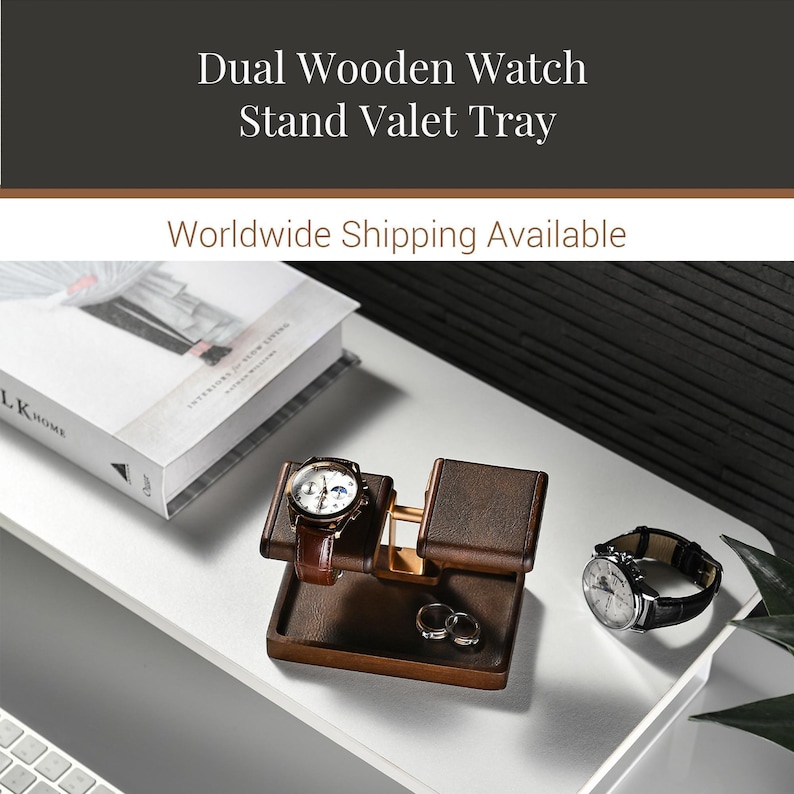 a wooden watch stand with a watch and a ring on it, along with a book and a plant on a desk.