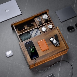 a wooden box containing a cell phone, watch, and other items