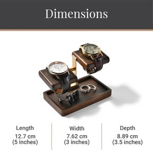 A wooden watch stand with two watches on it, along with some rings and a pen holder.
