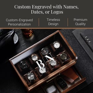 A wooden watch case with multiple watch faces visible inside, along with a black leather-bound notebook and a glass of wine.