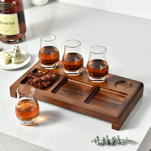 a selection of drinks and food items arranged on a wooden tray, accompanied by a bottle of Heineken wine.
