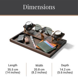 A wooden tray with various items, including a pair of sunglasses, a wallet, and a watch stand, arranged on it.