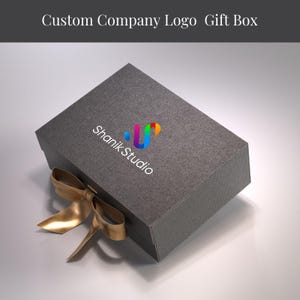 A gray gift box with a gold ribbon tied around it, featuring the logo of Shank Studio.