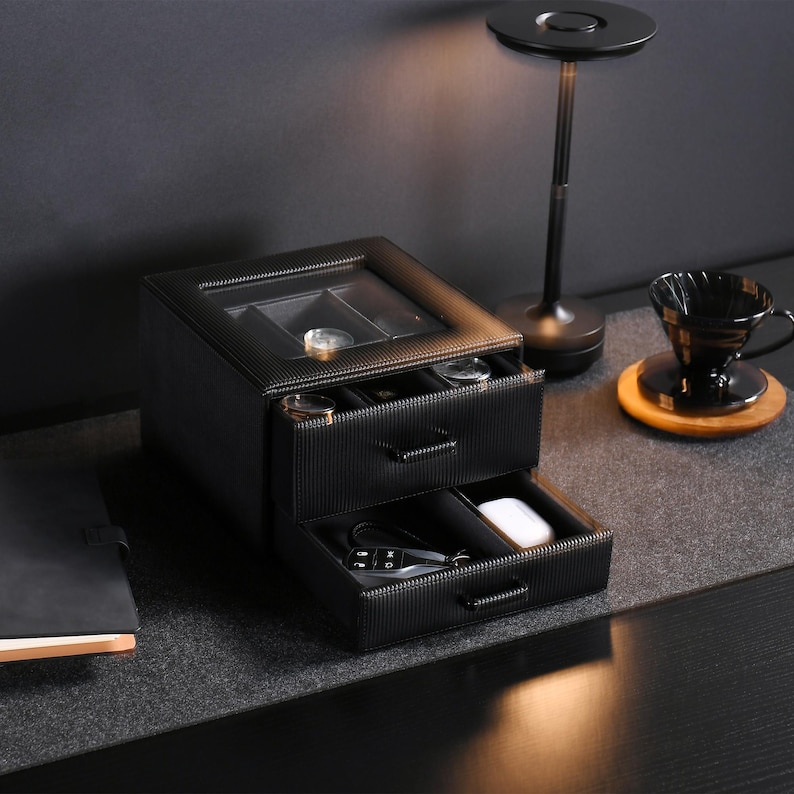 a table with a lamp and a black box on it