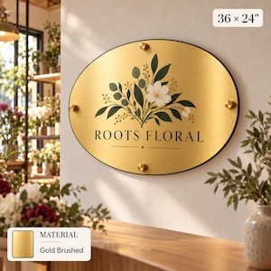 a decorative sign for " Roots Floral" with a floral design and the text "MATERIAL Gold Brushed" on a wooden surface.