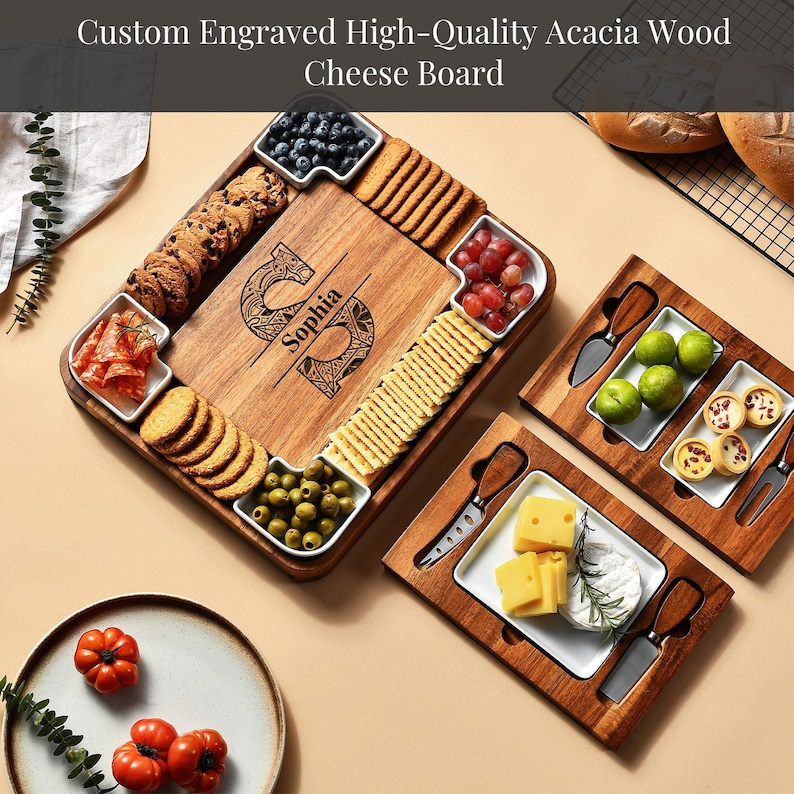 a custom engraved high-quality acacia wood cheese board with various food items arranged on it. The cheese board includes a variety of cheeses, crackers, grapes, and other snacks. The cheese board is accompanied by a plate of tomatoes and a plate of bread. The image also includes a decorative element, a plant, and a tray with additional food items.