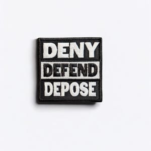 May include: Black and white embroidered patch with the words "DENY DEFEND DEPOSE" in white lettering on a black background.