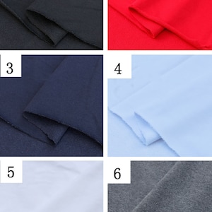 May include: Six fabric swatches in different colors: black, red, navy blue, light blue, white, and gray. The fabric is folded and the edges are visible.