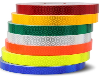 May include: A stack of six rolls of reflective tape in various colors, including red, yellow, green, white, orange, and blue. Each roll has a diamond pattern.