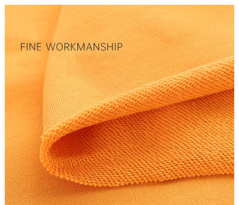May include: Close-up of a bright orange fabric with a textured knit pattern. The fabric is folded over, showing the inside of the knit. The text "FINE WORKMANSHIP" is visible in the top left corner.