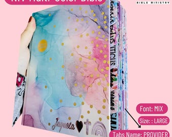 May include: A multi-colored NIV Bible with gold accents and a watercolor design. The Bible has tabs with the names of the books of the Bible. The Bible is labeled "NIV Multi-Color Bible" and "Jesus Bible Ministry".