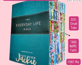 May include: A teal Bible titled The Everyday Life Bible with commentary by Joyce Meyer and the name Jackie printed on the cover. The book features a black horizontal band and a series of colorful, patterned index tabs labeled with various books of the Bible.